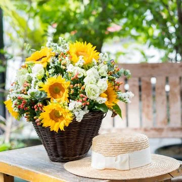 Sunflower in the basket  with hat on the table Stock Photos