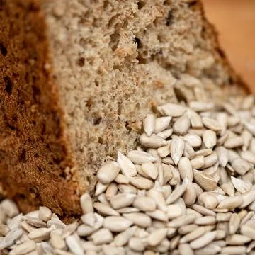 Sunflower grains on background of cereal bread. Healthy grain bread. Fresh baked Stock Photos