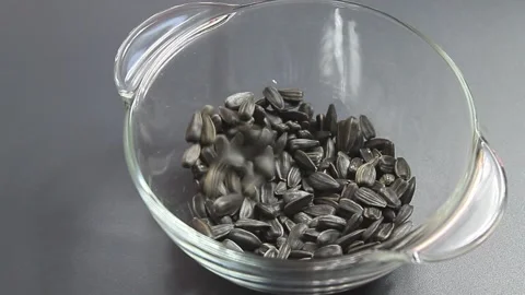 Sunflower seeds falling into a bowl Stock Footage 150406483