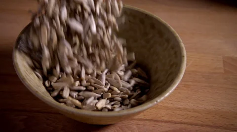 Sunflower seeds falling into dish, slow motion Stock Footage 55708771