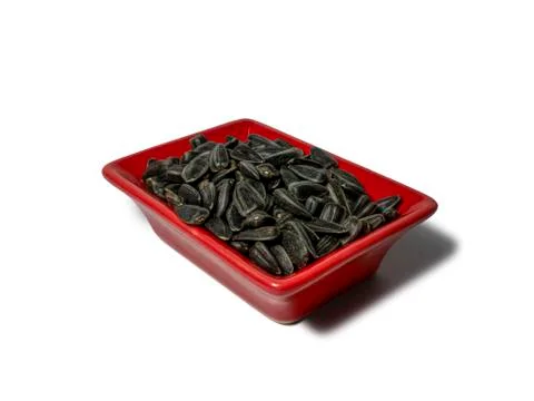 Sunflower seeds in a red rectangular saucer isolated on white background. Clo Stock Photos