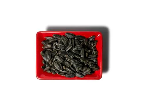Sunflower seeds in a red rectangular saucer isolated on white background. The Stock Photos
