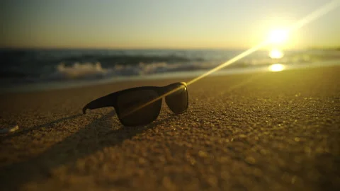 Sunglass on sand at beach sunset Video stock 212990994