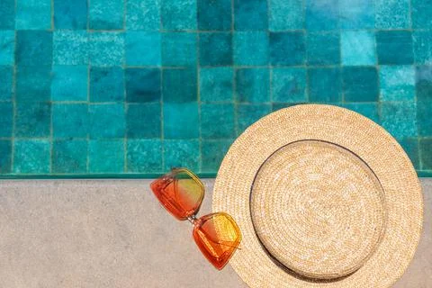 Sunglasses and a hat by the pool. Flatlay by the pool. Summer concept. Stock Photos