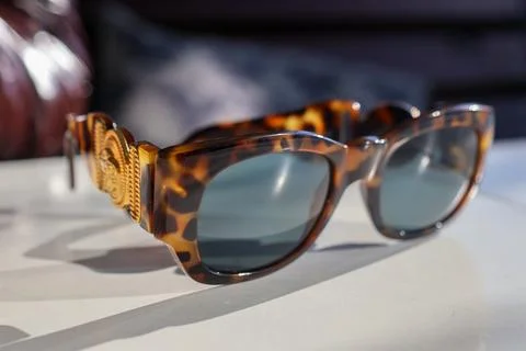 Sunglasses are placed on a table in a room with soft light coming in from a.. Stock Photos