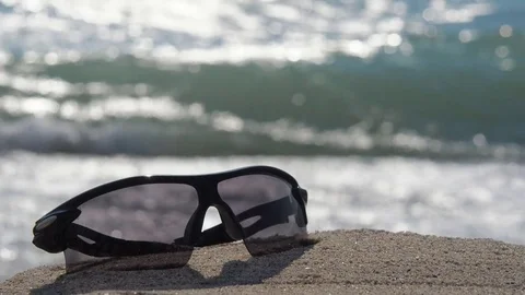 Sunglasses on a background of waves. Stock Footage