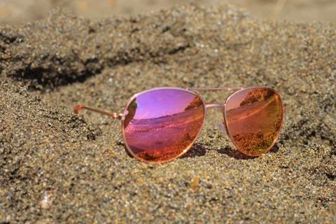 Sunglasses at the beach with sea reflection. Stock Photos