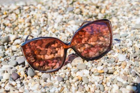 Sunglasses on the beach of small pebbles Stock Photos