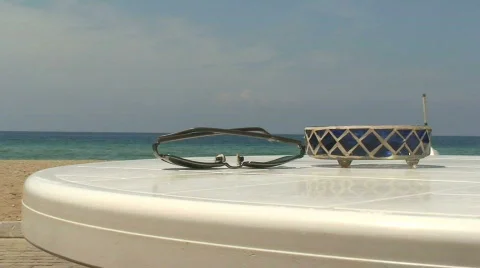 Sunglasses on a beach table Stock Footage 78031
