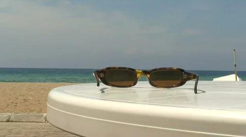 Sunglasses on a beach table 스톡 동영상 78038