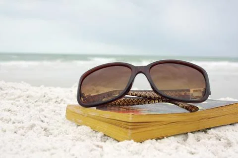 Sunglasses on book at beach Stock Photos