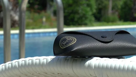 Sunglasses Case Next To Swimming Pool Stock Footage 111591502
