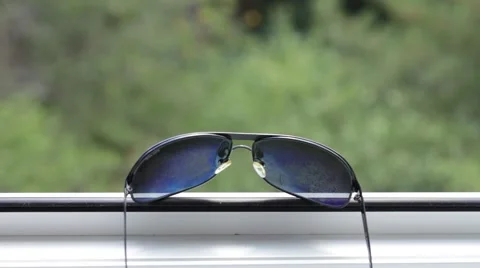 Sunglasses in front of a window Stock Footage 66755883