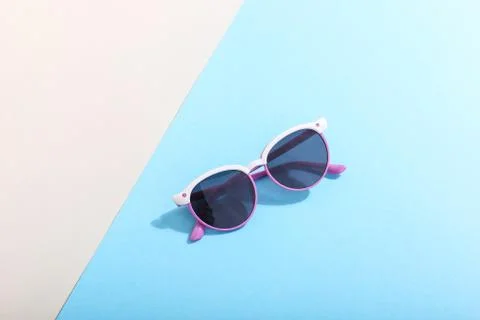 Sunglasses lie on a colored background casting a harsh shadow, concept art of Stock Photos
