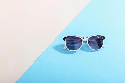 Sunglasses lie on a colored background casting a harsh shadow, concept art of Stock Photos