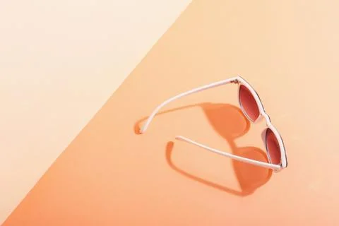 Sunglasses lie on a colored background casting a harsh shadow, concept art of Stock Photos