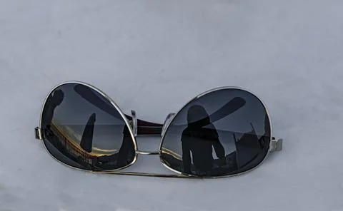 Sunglasses on a light background on the glasses a reflection of a beach umbrella Foto stock