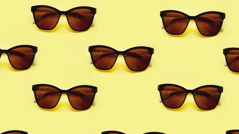 Sunglasses pattern on yellow background with the shadows Stock Photos