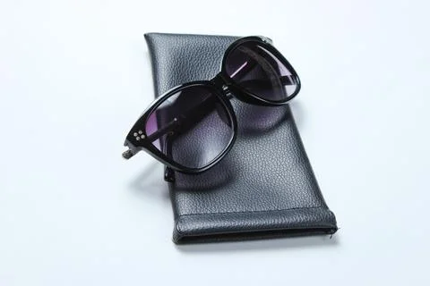 Sunglasses with protective leather case on gray background. 库存照片