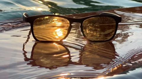 Sunglasses Resting on Pool Edge at Sunset Stock Footage 348251879