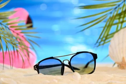 Sunglasses on the sand on the sandy seashore. Stock Photos