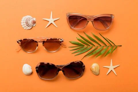 Sunglasses with seashell lying on table background. Sunglasses on summer back Stock Photos