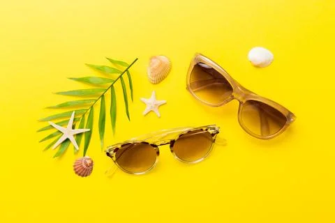 Sunglasses with seashell lying on table background. Sunglasses on summer back Stock Photos