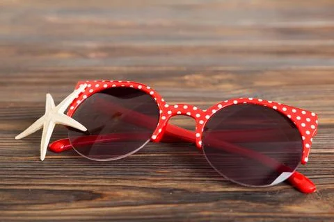 Sunglasses with seashell lying on table background. Sunglasses on summer ba.. Stock Photos
