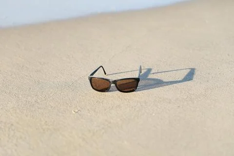 Sunglasses with shawdow on the sandy beach Foto stock
