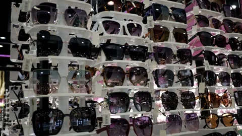 Sunglasses from a showcase in a store, close-up. Optics shop. The windscreen off Stock Footage 268602043