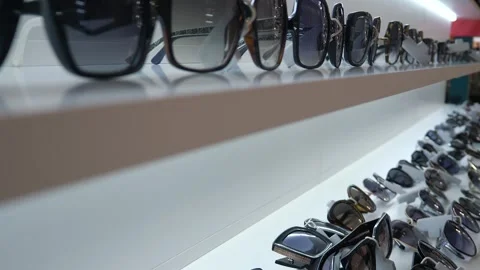 A Sunglasses standing in a row on a shop window. Selecting glasses. Stock Footage 314091760
