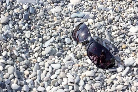 Sunglasses on the stone beach Stock Photos