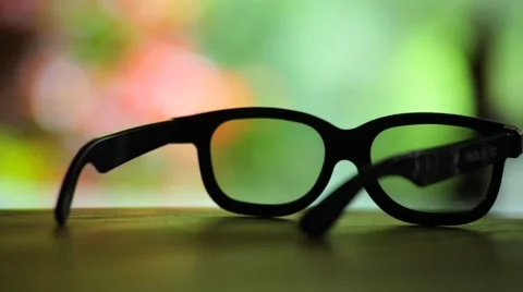 Sunglasses on a table over looking colourfull natrual setting Stock Footage 63808828