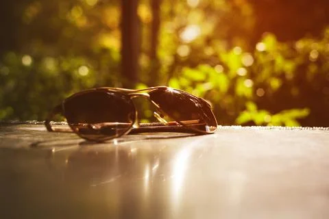 Sunglasses   on a   table.  Selective focus. Sunset light Stock Photos