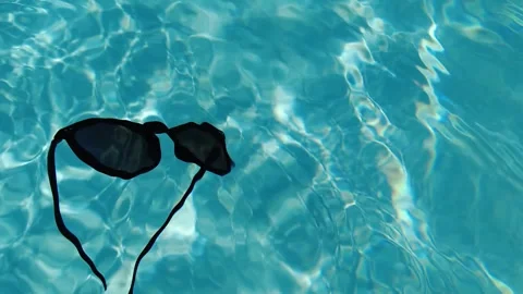 Sunglasses in water pool. Slow motion video. 스톡 동영상 245064257