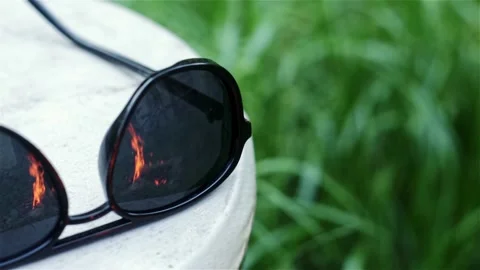 Sunglasses in which burning fire and bicycle are reflected. Stock Footage 210238380