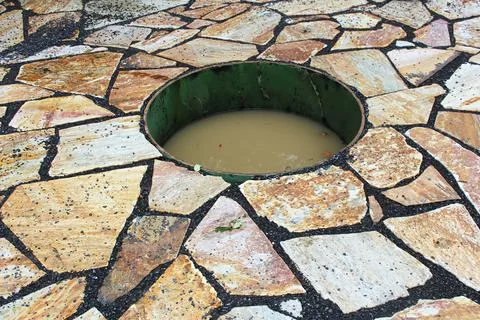 A sunked fire pit on a stone patio filled with water Stock Photos