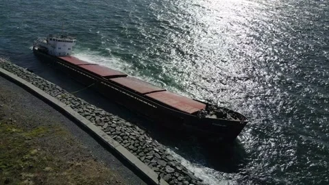 A sunken cargo ship that hit the shore is damaging the environment. Stock Footage 148429742