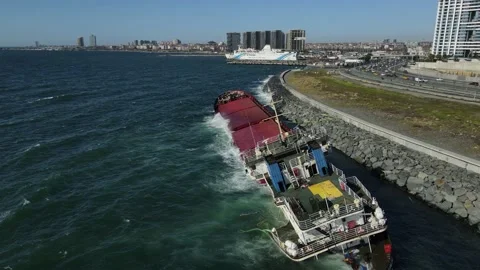 A sunken cargo ship that hit the shore is damaging the environment. Stock Footage 148431502