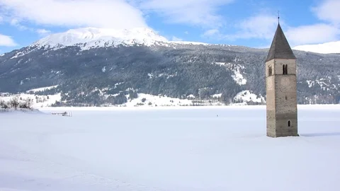 Sunken clock tower in the iced lake of Resia (Reschensee) Stock Footage 94142220