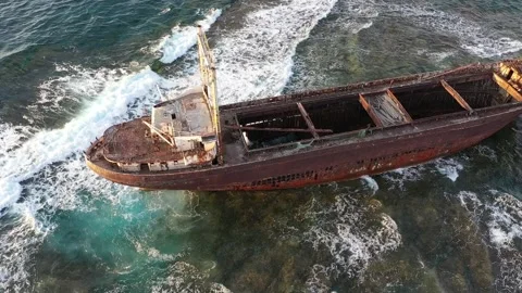The sunken rusty ship has been lying on the rocks for many years. Stock Footage 139865599