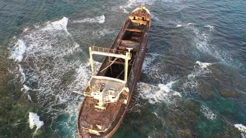 The sunken rusty ship has been lying on the rocks for many years. Stock Footage 139866005