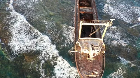 The sunken rusty ship has been lying on the rocks for many years. Stock Footage 139867260