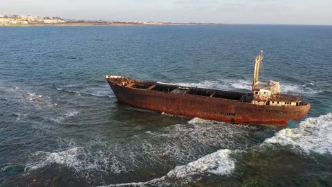 The sunken rusty ship has been lying on the rocks for many years. Stock Footage 139867671
