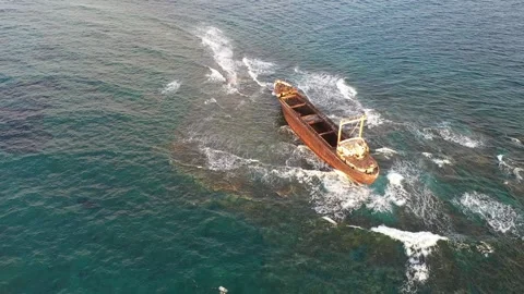 The sunken rusty ship has been lying on the rocks for many years. Stock Footage 139867805