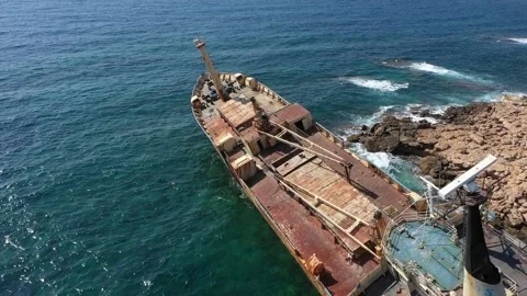 The sunken rusty ship was thrown on the rocks near the shore. Stock Footage 139680316