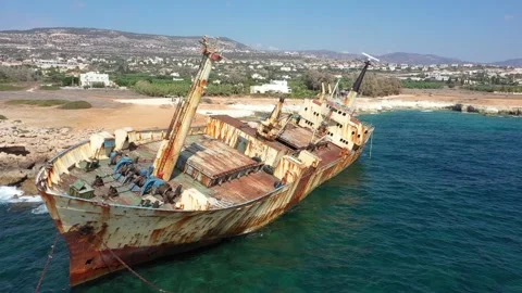 The sunken rusty ship was thrown on the rocks near the shore. Stock Footage 139681819