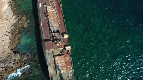 The sunken rusty ship was thrown on the rocks near the shore. Stock Footage 139682295