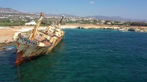 The sunken rusty ship was thrown on the rocks near the shore. Stock Footage 139684053