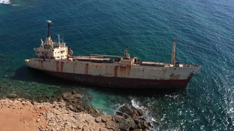 The sunken rusty ship was thrown on the rocks near the shore. Stock Footage 139684357
